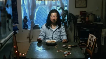 Still from Death and Ramen showing Death and ramen chef sharing a meal in dimly lit kitchen