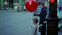 The Red Balloon 1956 film scene showing a young boy with a bright red balloon in Paris streets